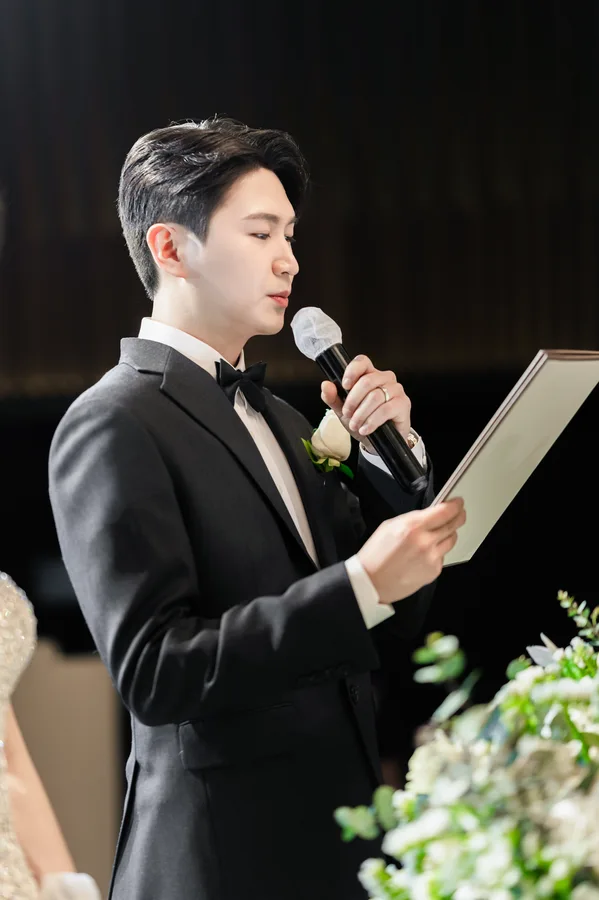 마이크를 들고 성혼 서약문을 읽는 신랑의 옆모습