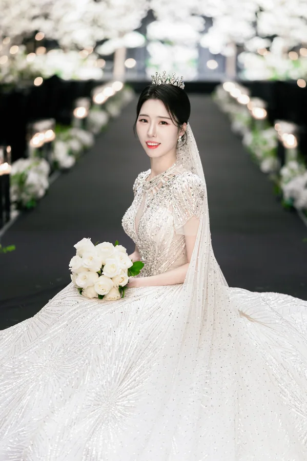 버진로드 조명 배경 속 부케를 든 신부의 단독 인물컷