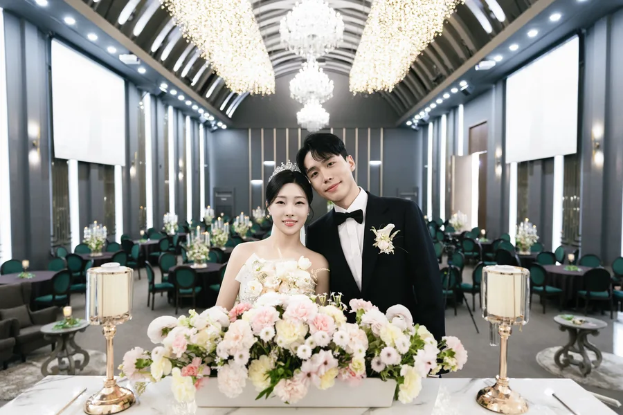 샹들리에 늘어진 인천 웨스턴팰리스 웨스턴홀 전경, 화동 테이블 앞에 나란히 선 신랑신부